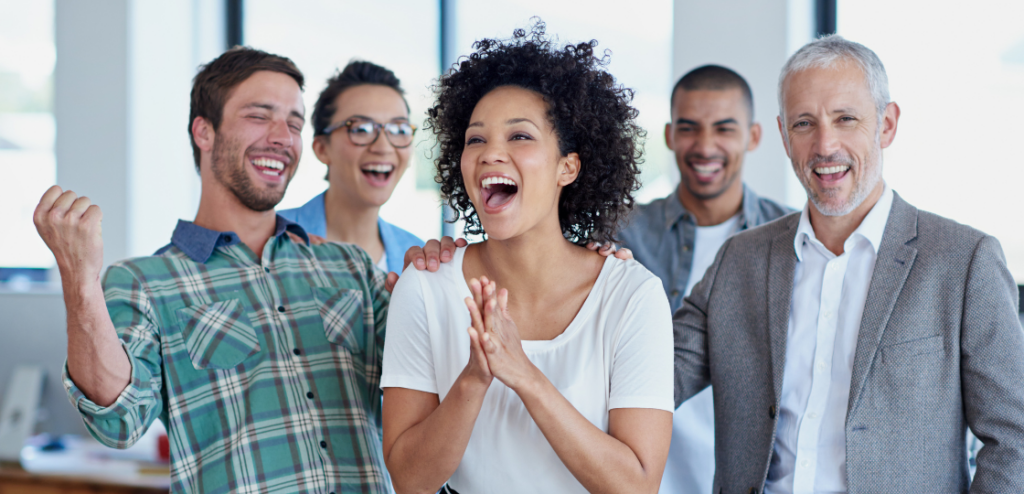 Shot of a group of happy SaaS Sales coworkers celebrating standing in an office.