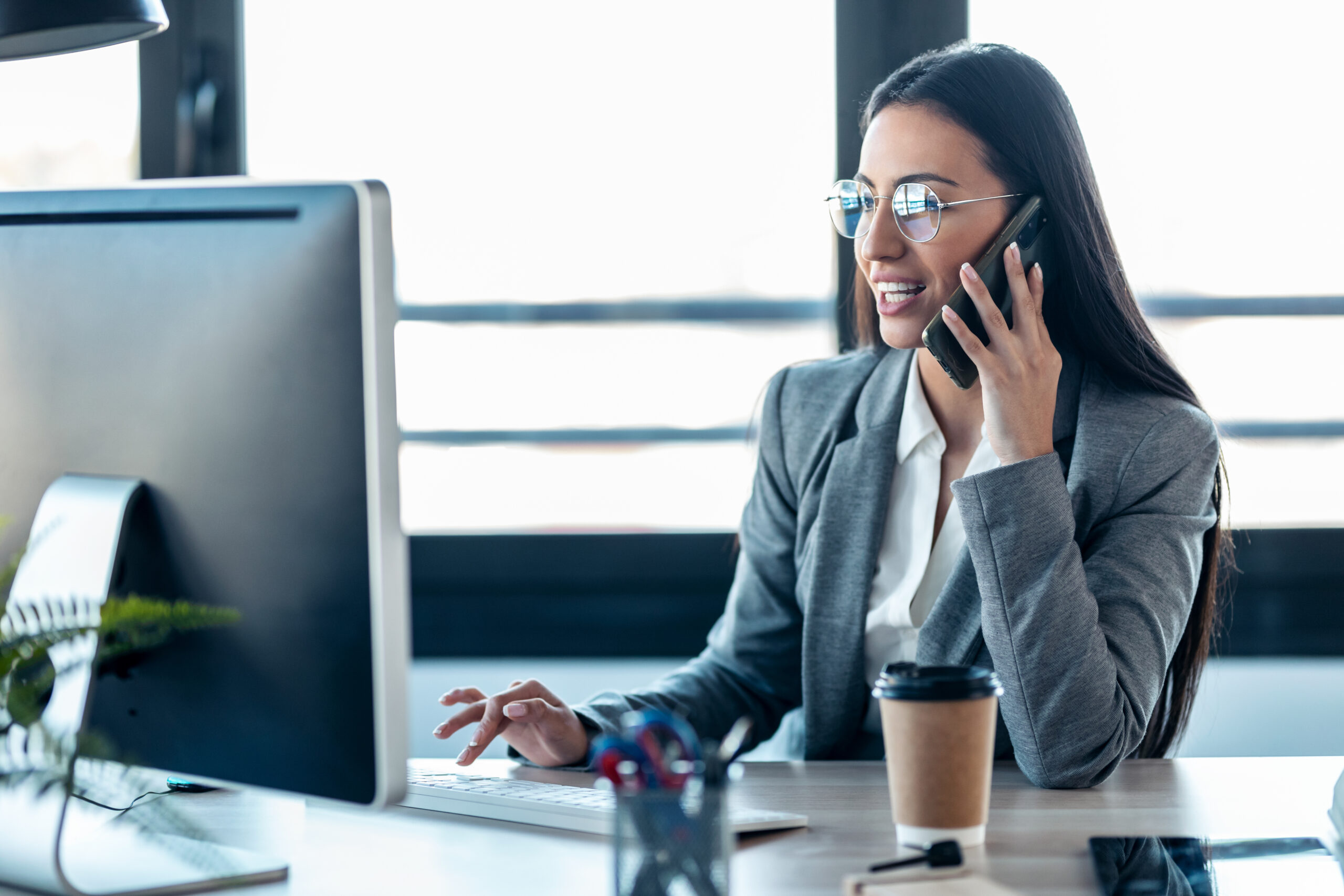 A SaaS sales representative sitting at a desk, sending a personalized outbound email to a potential client, highlighting the initial step of the sales process.