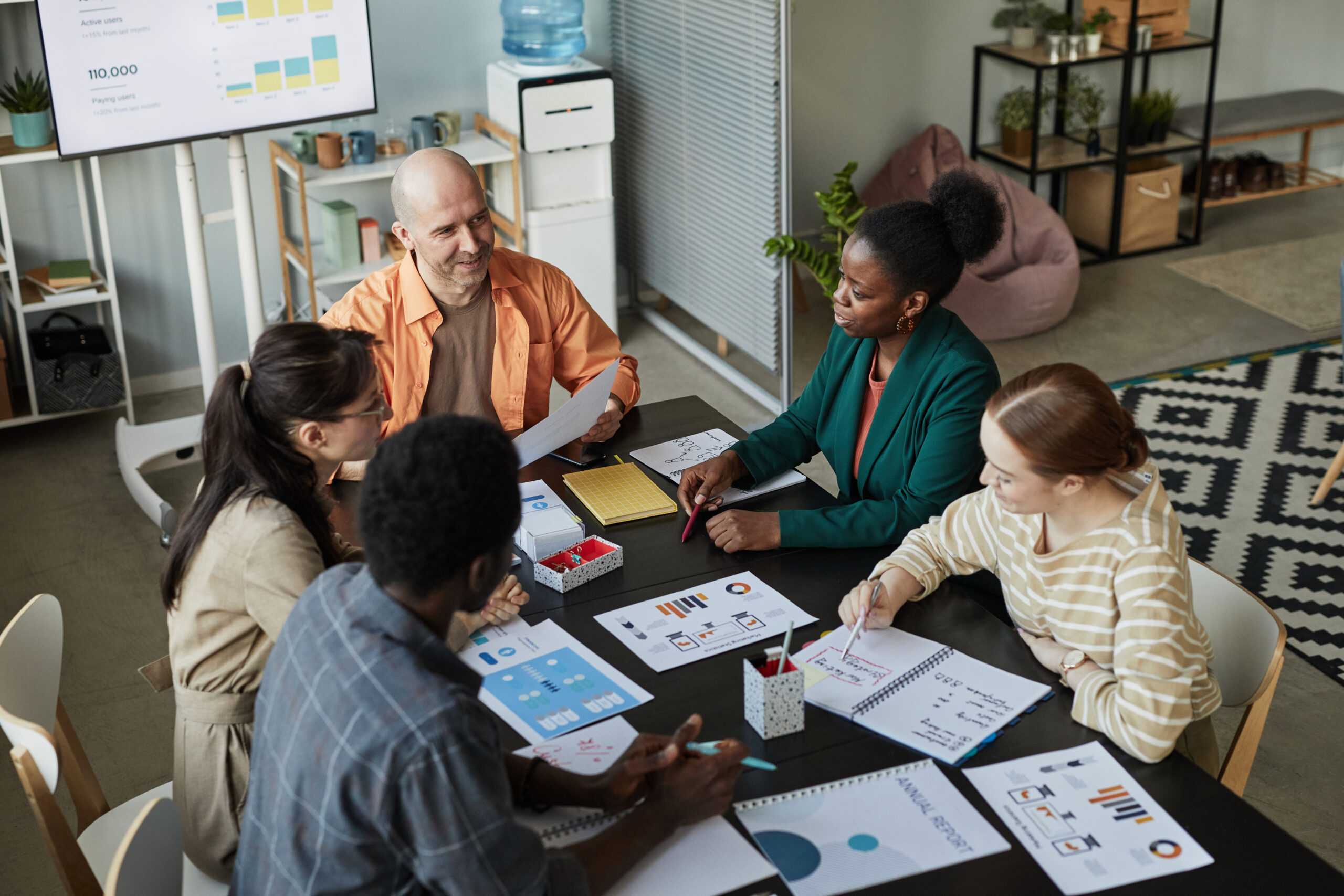 A diverse team of professionals engaged in a brainstorming session, symbolizing collaboration and teamwork in SaaS sales.