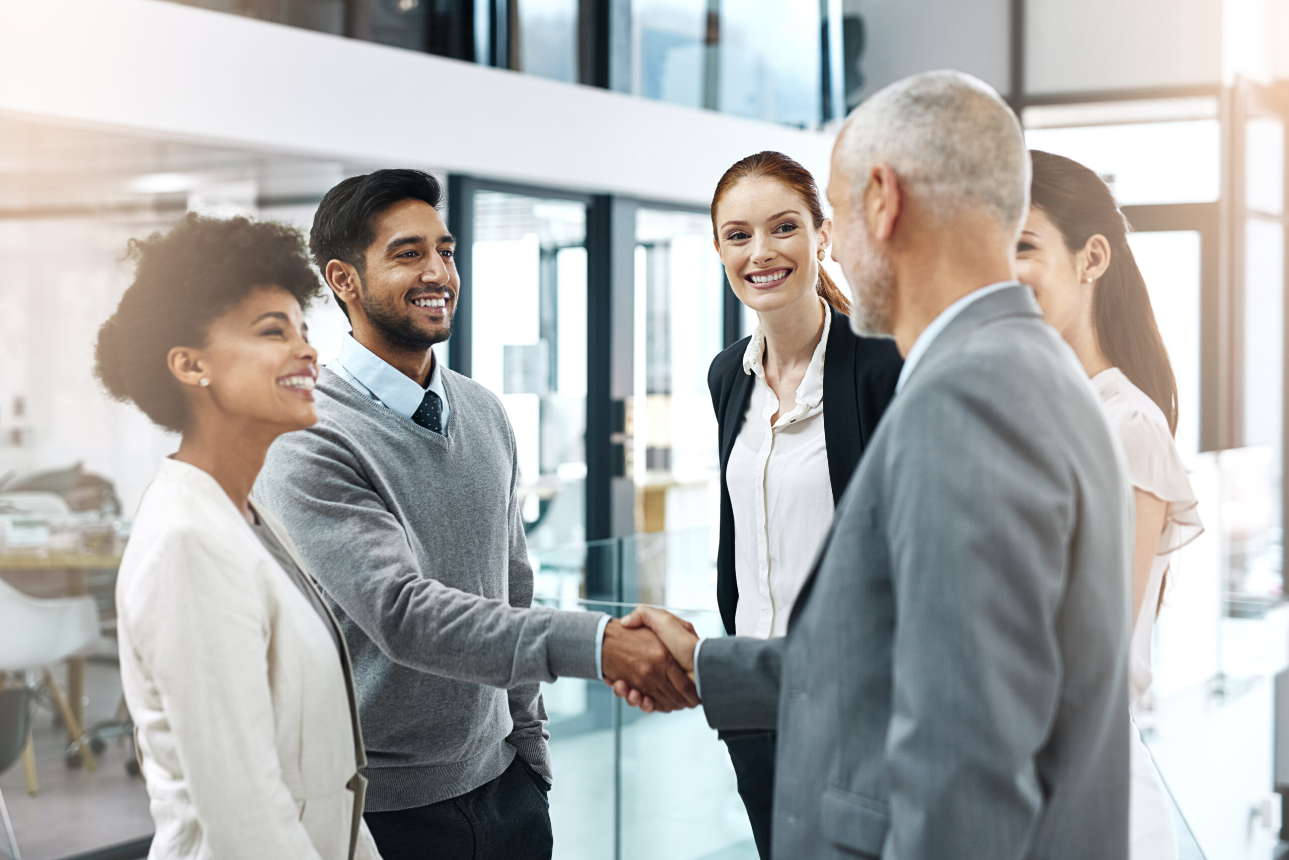 A hand reaching out to shake another hand, illustrating a successful deal negotiation and partnership in SaaS sales.