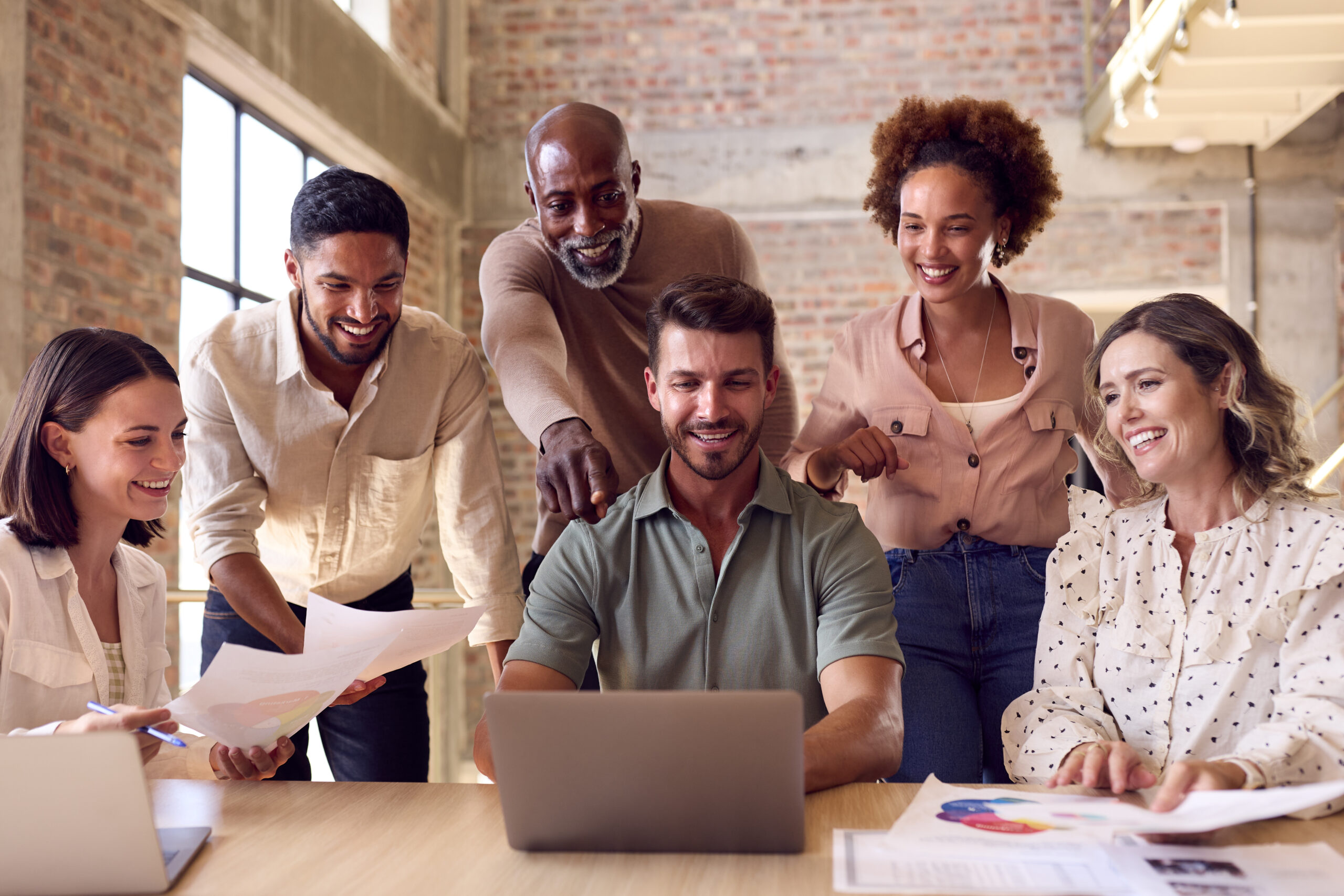 A diverse team of SaaS sales professionals working together in an office, highlighting collaboration and teamwork.