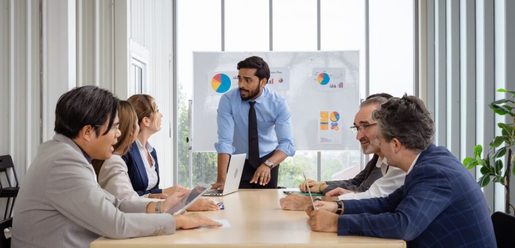 A diverse group of business professionals discussing sales strategies in a modern office environment, representing the role of a Sales Director in a SaaS company.