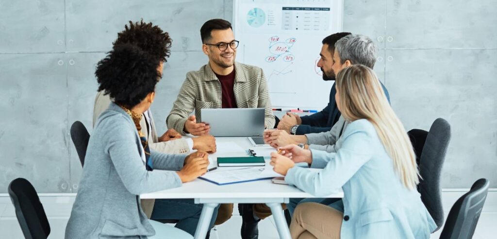 A group of professionals discussing in an office setting, representing teamwork and collaboration in fintech sales.