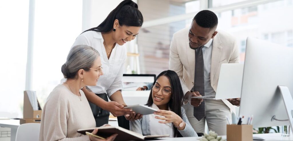 A group of business professionals collaborating in an office, symbolizing teamwork and the recruitment process in the software sales industry.