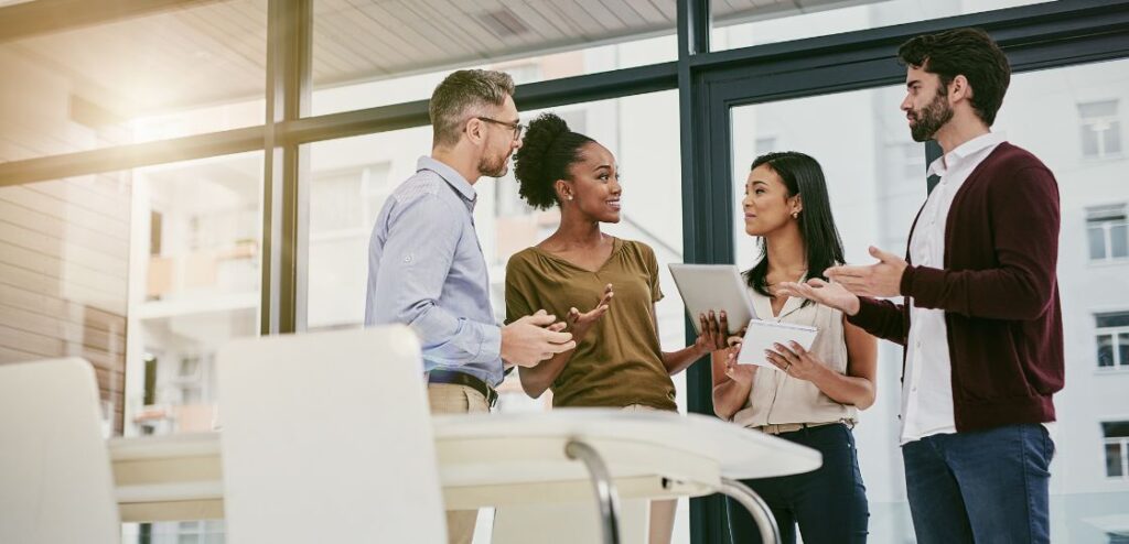 Group of professionals in an office discussing software solutions, representing the collaborative nature of a career in software sales.