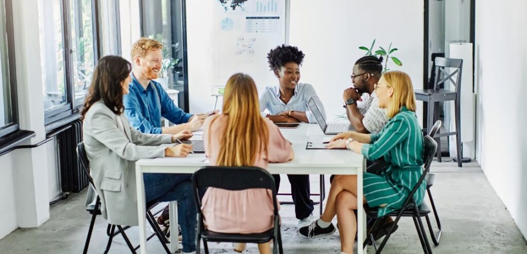 Group of professionals engaged in a meeting, discussing business strategies around a conference table.