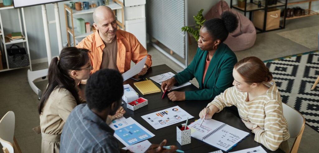 A diverse team of professionals engaged in a brainstorming session, symbolizing collaboration and teamwork in SaaS sales.