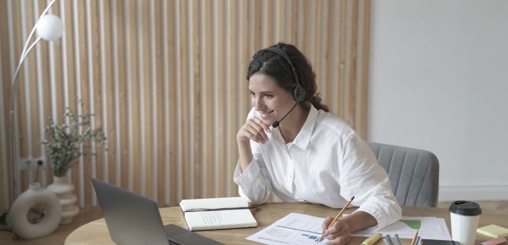 An inside sales representative working from home, using a laptop and phone to communicate with clients, showcasing the remote nature of the job.