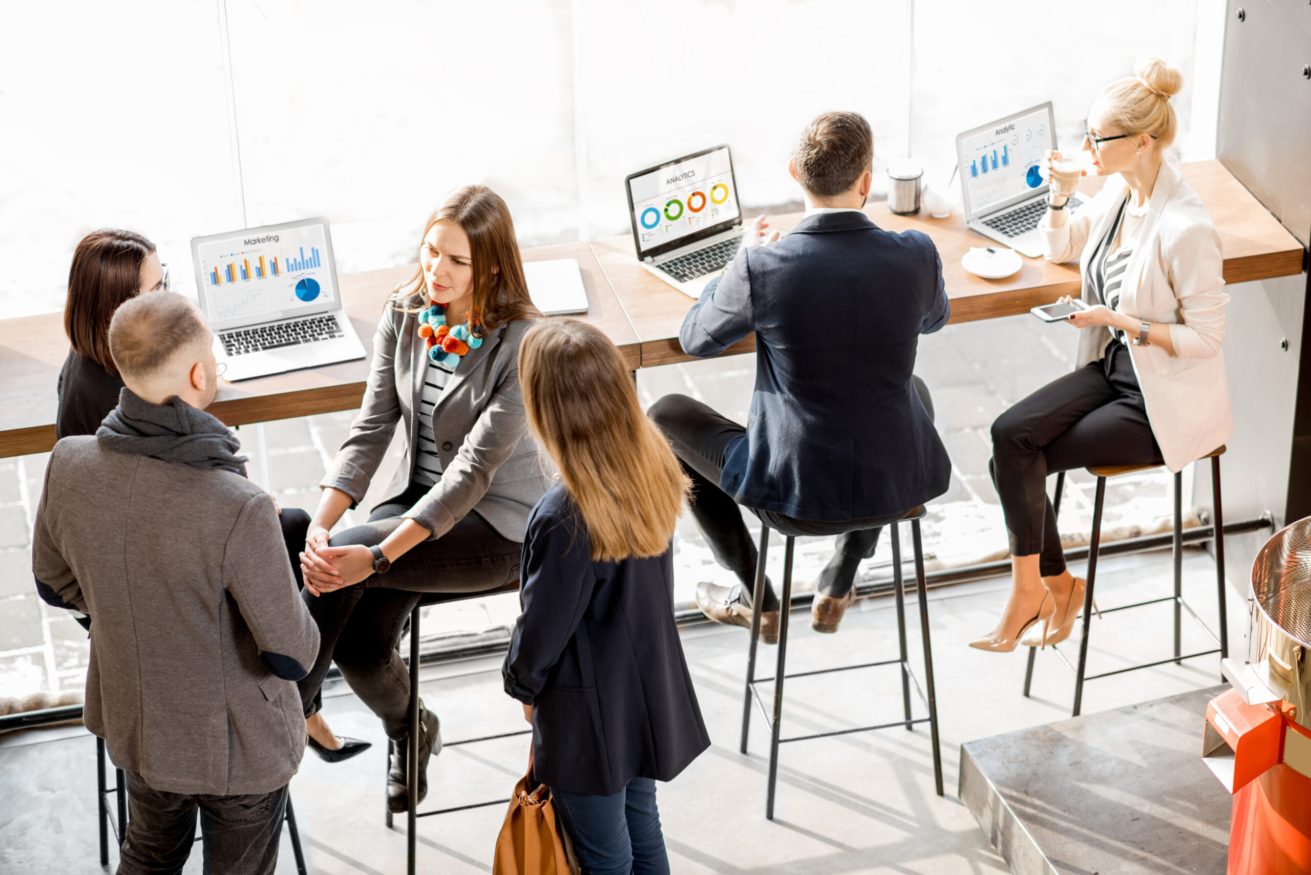 SaaS Sales Business people having a conversation and working with laptops.